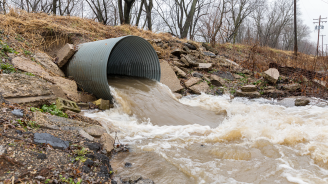 image of storm drain with water rushing out